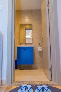 a bathroom with a blue sink and a mirror at Luxe Romance Retreat for Couples in Nairobi