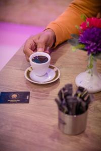 een persoon met een kopje koffie op een tafel bij golden palace down town in Caïro