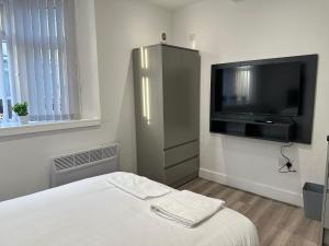 sypialnia z telewizorem z płaskim ekranem i łóżkiem w obiekcie Studio Flat in Luton Town Centre w Luton