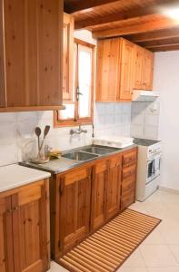 una cucina con armadi in legno e lavandino di Gloria's house a Mykonos Città