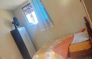 um pequeno quarto com uma cama e uma janela em Pousada Apucarana em Apucarana