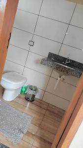 a bathroom with a toilet on a wooden floor at Pousada Apucarana in Apucarana