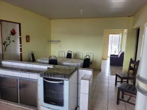 une cuisine avec une cuisinière et une cuisine avec un lit dans l'établissement Apartamento Imobiliaria Oliveira, à Sete Barras