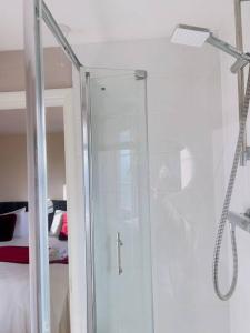 a shower with a glass door in a bathroom at Starview Apartment-Vitoria in Lexden