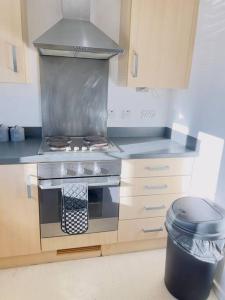 a kitchen with a stove and a trash can at Starview Apartment-Vitoria in Lexden
