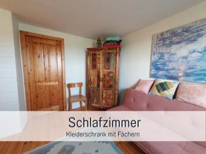 斯泰恩伯格Fewo Kleines Nest strandnah optimal für Alleinreisende und Paare的带沙发和木柜的客厅