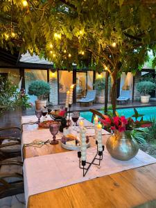 a long table with candles on it with a tree at CHERRY VINTAGE HOME in Târgovişte