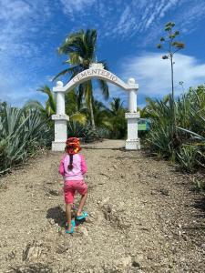 a little girl standing in front of a sign at Deer House Cabuya in Cabuya