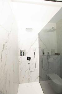 a white bathroom with a shower and a sink at Moderne Wohnung mit Panorama in Schneppenbach