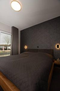 a bedroom with a large bed and a large window at Moderne Wohnung mit Panorama in Schneppenbach