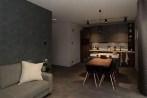 a living room with a couch and a table and a kitchen at Moderne Wohnung mit Panorama in Schneppenbach
