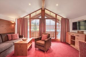 ein Wohnzimmer mit einem Sofa und einem TV in der Unterkunft Landhotel Berghof in Bad Hindelang