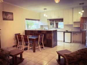 a kitchen with a table and chairs in a room at The Blow-Inn Farmer, Sunrise Cottage in Howick