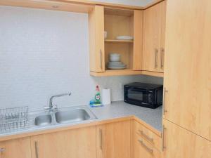 a kitchen with a sink and a microwave at 2 Bedroom Flat in Colchester in Colchester