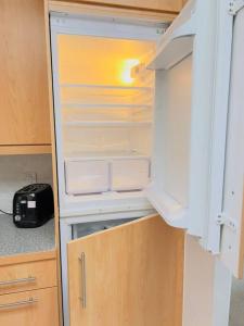 an empty refrigerator with its door open in a kitchen at 2 Bedroom Flat in Colchester in Colchester