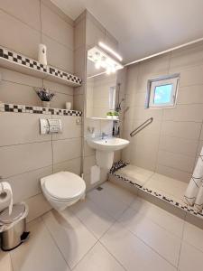 a white bathroom with a toilet and a sink at Apartament Flora in Odorheiu Secuiesc