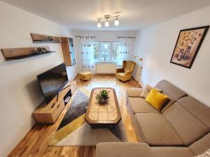 ein Wohnzimmer mit einem Sofa und einem Tisch in der Unterkunft Apartament Flora in Odorheiu Secuiesc
