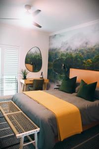 a bedroom with a large bed with a painting on the wall at Designer Luxe Stellies Studio in Stellenbosch