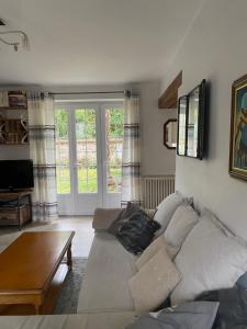ein Wohnzimmer mit Sofa und Tisch in der Unterkunft Maison familiale au coeur de la vallée de l'Eure in Breuilpont