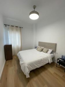 ein weißes Schlafzimmer mit einem großen Bett mit weißer Bettwäsche in der Unterkunft Málaga-Centro in Málaga