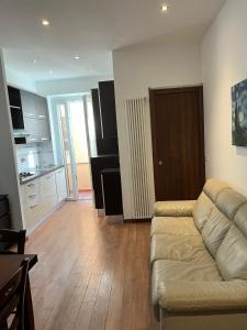 a living room with a couch and a kitchen at Appartamento sul lungomare in centro Ladispoli in Ladispoli