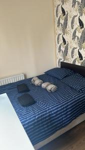 a bed with a blue comforter and two pillows at Roy's House in Dublin