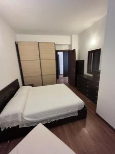 a bedroom with a large white bed and wooden floors at Appartamento sul lungomare in centro Ladispoli in Ladispoli