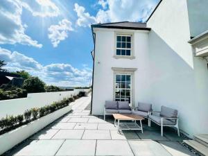 a patio with two chairs and a table on a white building at Islandon House The Jurassic Coast in Hamworthy