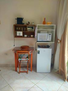 cocina con mesa pequeña y microondas en Suite Borboleta, en Ilhabela
