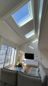 een woonkamer met een plafond met een dakraam bij Duplex 160m2 Paris JO 2024 in Vincennes