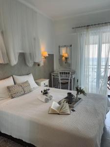 una camera da letto con un grande letto bianco con due libri sopra di Hotel Avlakia a Kokkari