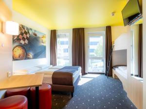 B&B Hotel Stuttgart-Zuffenhausen في شتوتغارت: غرفه فندقيه سريرين وتلفزيون