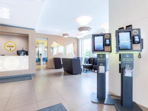 una hall con due monitor e una sala d'attesa di B&B Hotel Stuttgart-Zuffenhausen a Stoccarda