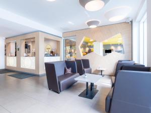 una sala d'attesa con sedie e un tavolo di B&B Hotel Stuttgart-Zuffenhausen a Stoccarda