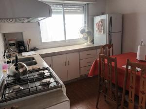 uma cozinha com um fogão, um lavatório e uma mesa em Casa Privada 2 habitaciones, amueblada Centro Necochea em Necochea