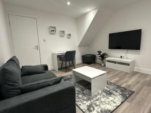 a living room with a couch and a flat screen tv at Modern Apartment in Luton town Centre in Luton