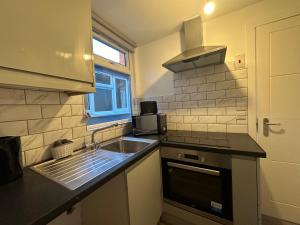 uma pequena cozinha com um lavatório e um micro-ondas em Modern Apartment in Luton town Centre em Luton