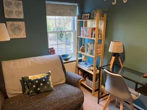 a living room with a couch and a desk at ROSEWOOD in Yoxford