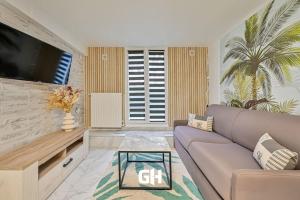 a living room with a couch and a tv at Le Must - Chambre double entre Paris et Disney in Livry-Gargan
