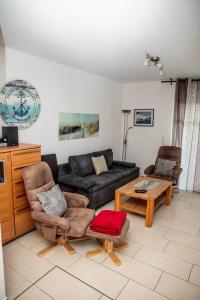 a living room with a couch and a table at Ferienwohnungen Saida Wohnung 9 in Norden