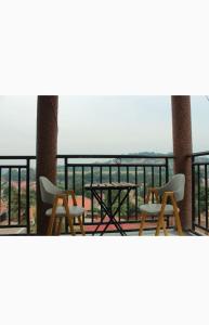 two chairs and a table on a balcony with the ocean at S A Apartments in Kampala