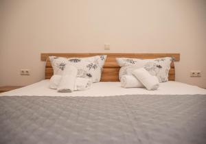 a bed with white pillows and a gray blanket at Ferienwohnungen Saida Wohnung 9 in Norden