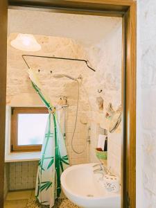 a bathroom with a sink and a shower at La Rosa dei Trulli B&B in Alberobello