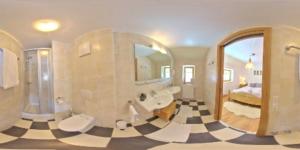 a bathroom with a large mirror and a checkerboard floor at Haus Weyerbach Apartments in Bramberg am Wildkogel