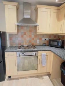 a kitchen with a stove and a microwave at Starview Apartment 101 in Colchester