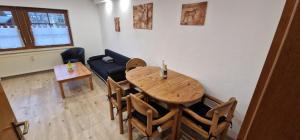 sala de estar con mesa, sillas y sofá en Ferienwohnung Walliser, en Friedenweiler