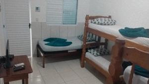a bedroom with two bunk beds and a desk at Pousada restaurante recanto do Marimar in Paraty