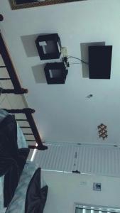 a room with a staircase and a tv on the wall at Pousada restaurante recanto do Marimar in Paraty
