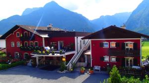 dwa czerwone domy z górami w tle w obiekcie Chalet Austria, up to 10 p, 15 min to salzburg city, garden with direct amazing mountainview, BBQ&bikes&sunbeds for free, 15 min sound of music w mieście Golling an der Salzach
