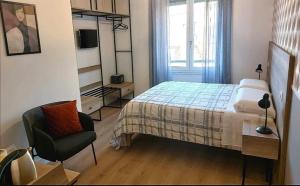 um quarto com uma cama, uma cadeira e uma janela em AnGiò holiday rooms em Nápoles